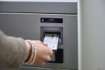 Frauenhand steckt girocard in Automat (nah)