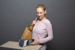 Frau mit Einkauf bezahlt mit Smartphone