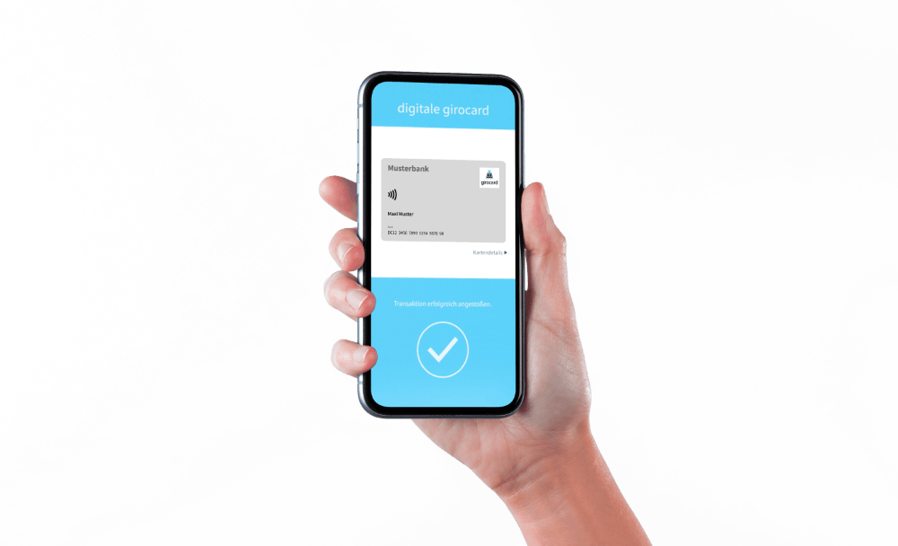 Hand hält ein Smartphone mit einer digitalen Girocard-Anzeige, die Informationen zur Musterbank und dem Nutzer zeigt, sowie einen Hinweis auf eine erfolgreiche Transaktion.
